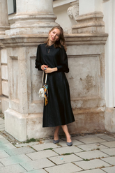 a lady in a black top and a black skirt made of xiangyun silk